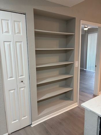 A white door with a shelf unit inside.
